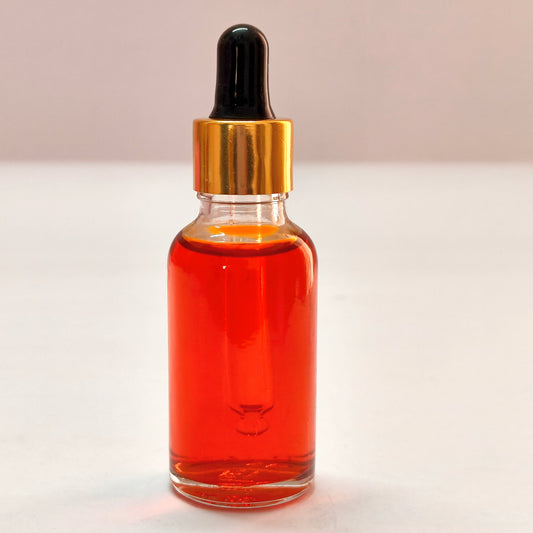 Glass dropper bottle with red liquid on a white background