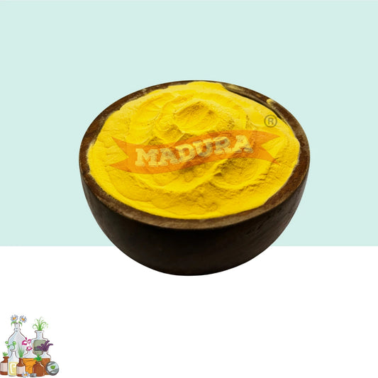 A dark brown wooden bowl filled with bright yellow turmeric powder, featuring a prominent orange 'MADURA' logo overlay, set against a split light blue and white background.