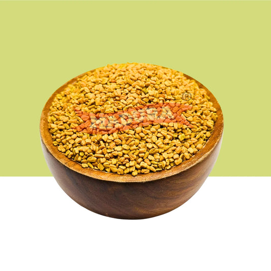 A wooden bowl filled with golden-yellow fenugreek seeds, centered against a split light green and white background.