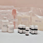 Assorted cosmetic bottles and packaging on a light pink background