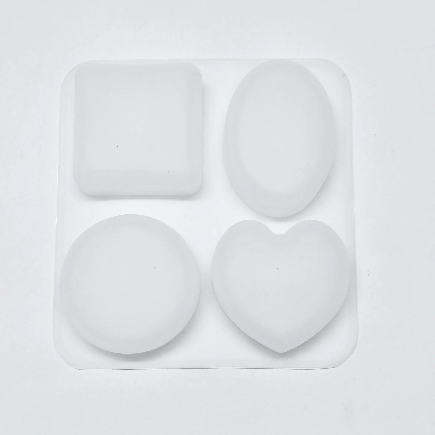 Set of four white silicone molds on a light gray background