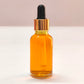 Amber glass dropper bottle with black cap on a white background
