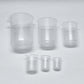 Set of clear glass beakers of different sizes on a white background