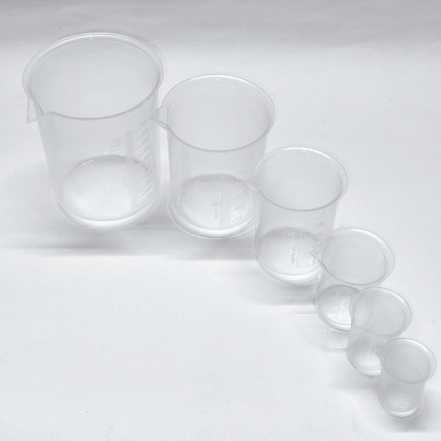 Set of clear plastic measuring cups on a white background