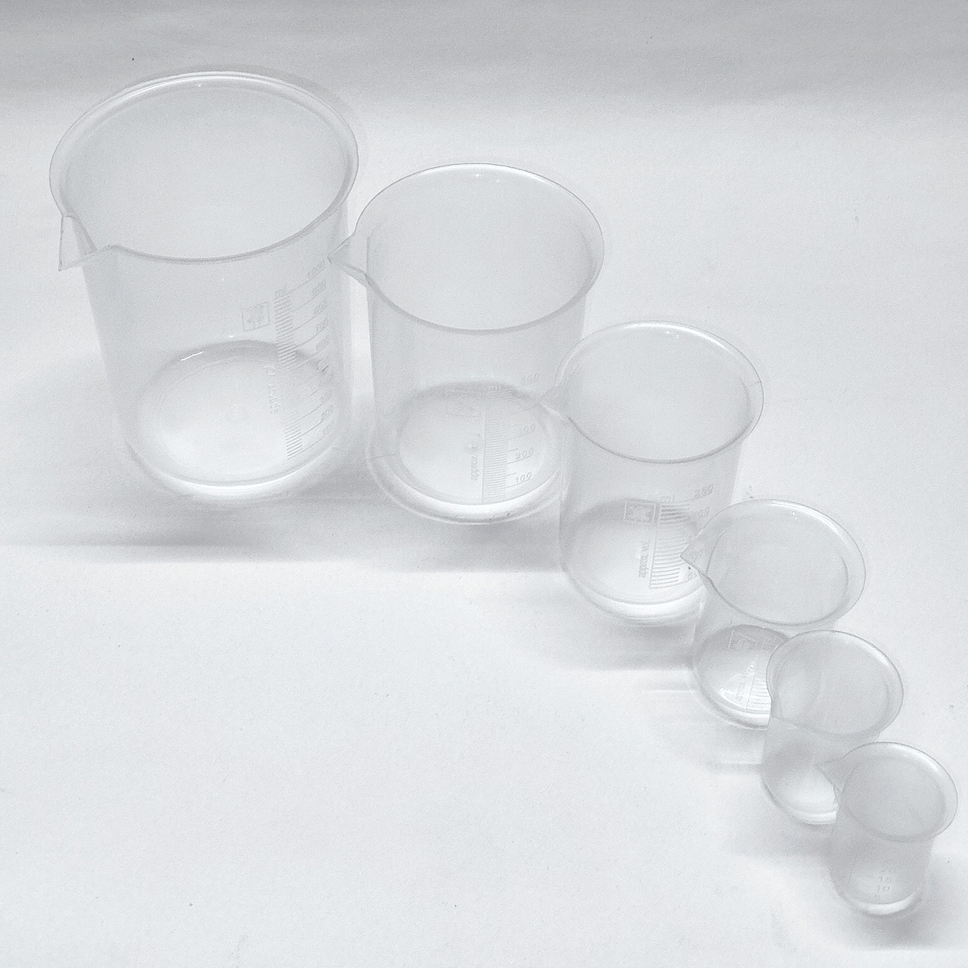 Set of clear plastic measuring cups on a white background
