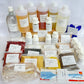 A large collection of herbal products from Madras Herbs Pvt Ltd, including multiple plastic bottles of liquid extracts, small vials, loose herbal powder bags, dried herbs, and a glass decanter, all neatly arranged on a white surface.