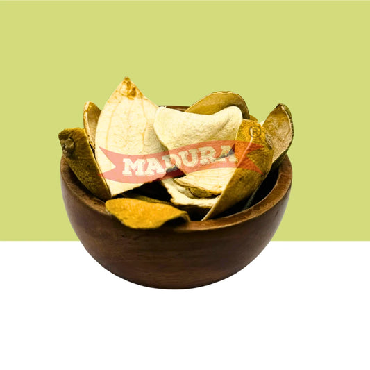 A top-down view of dried Orange Peel pieces arranged in a round brown bowl, with a red banner across the center reading 'MADURA'. The background is split horizontally with a light yellow-green upper half and white lower half.